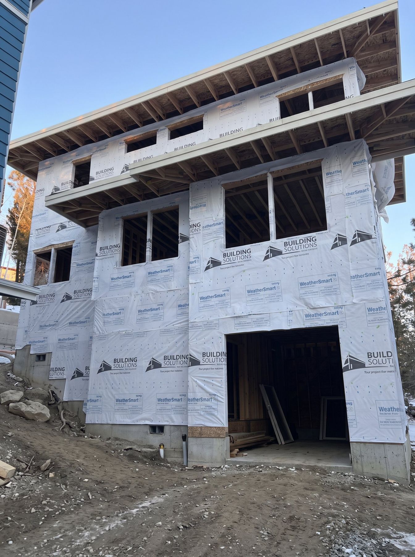 Two-story ADU framed and wrapped in weather barrier on a Bend building site