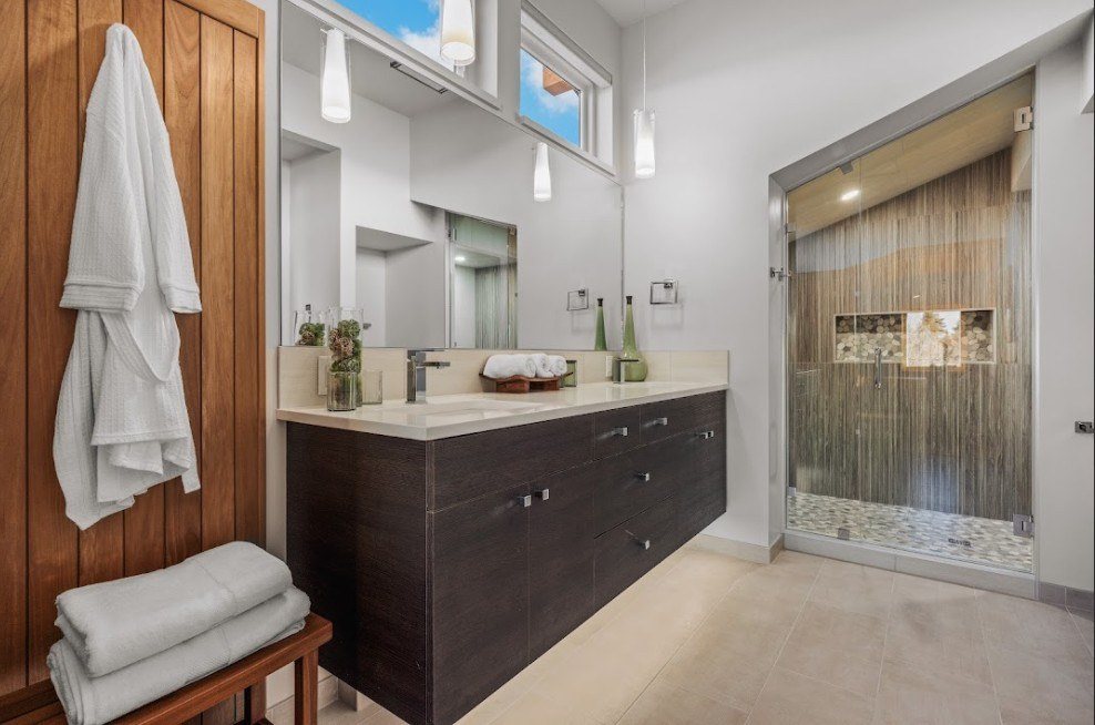 Finished bathroom with a floating vanity, wood accent wall and a tiled walk-in shower
