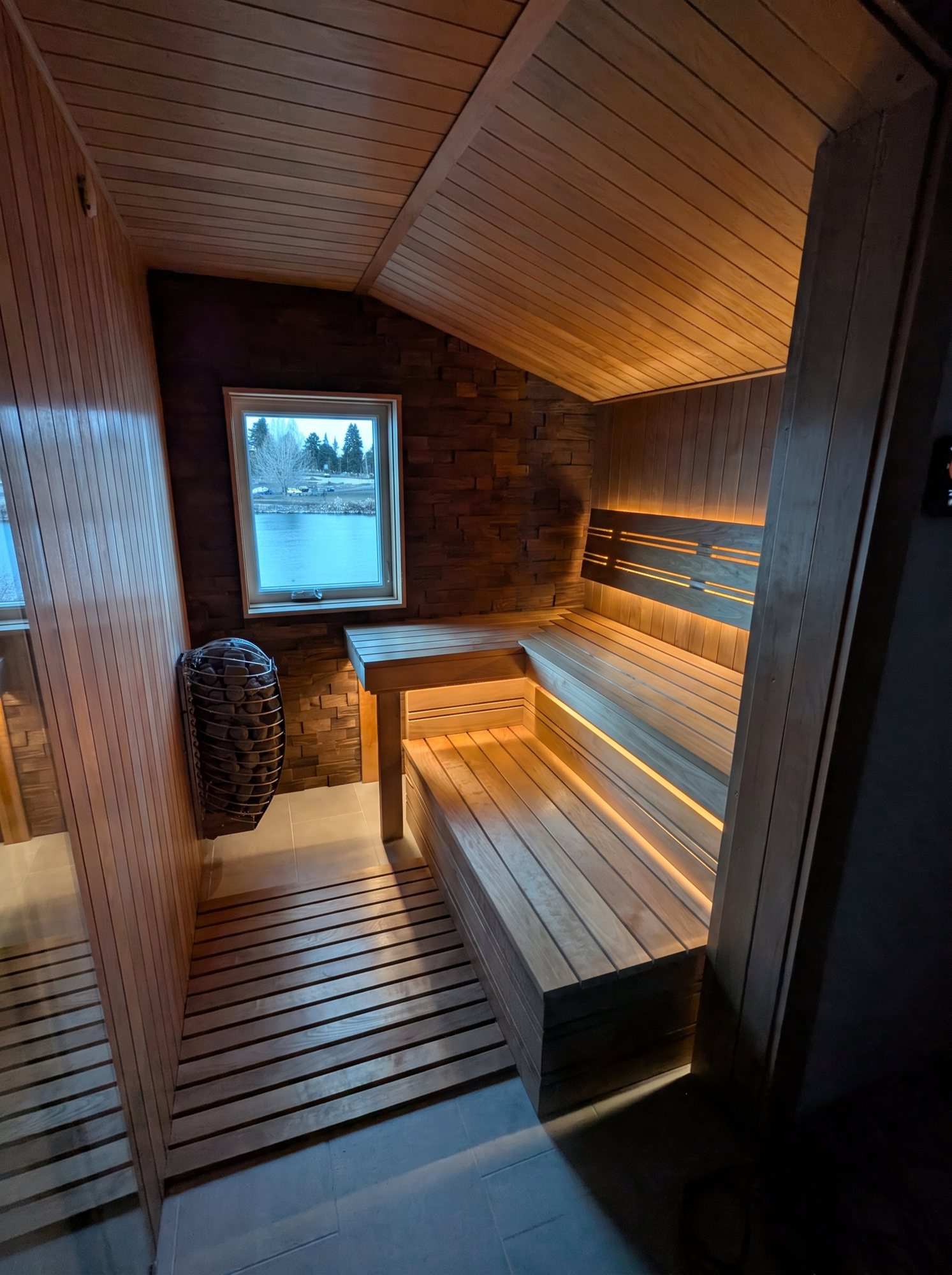 Finished cedar sauna with a window and bench seating