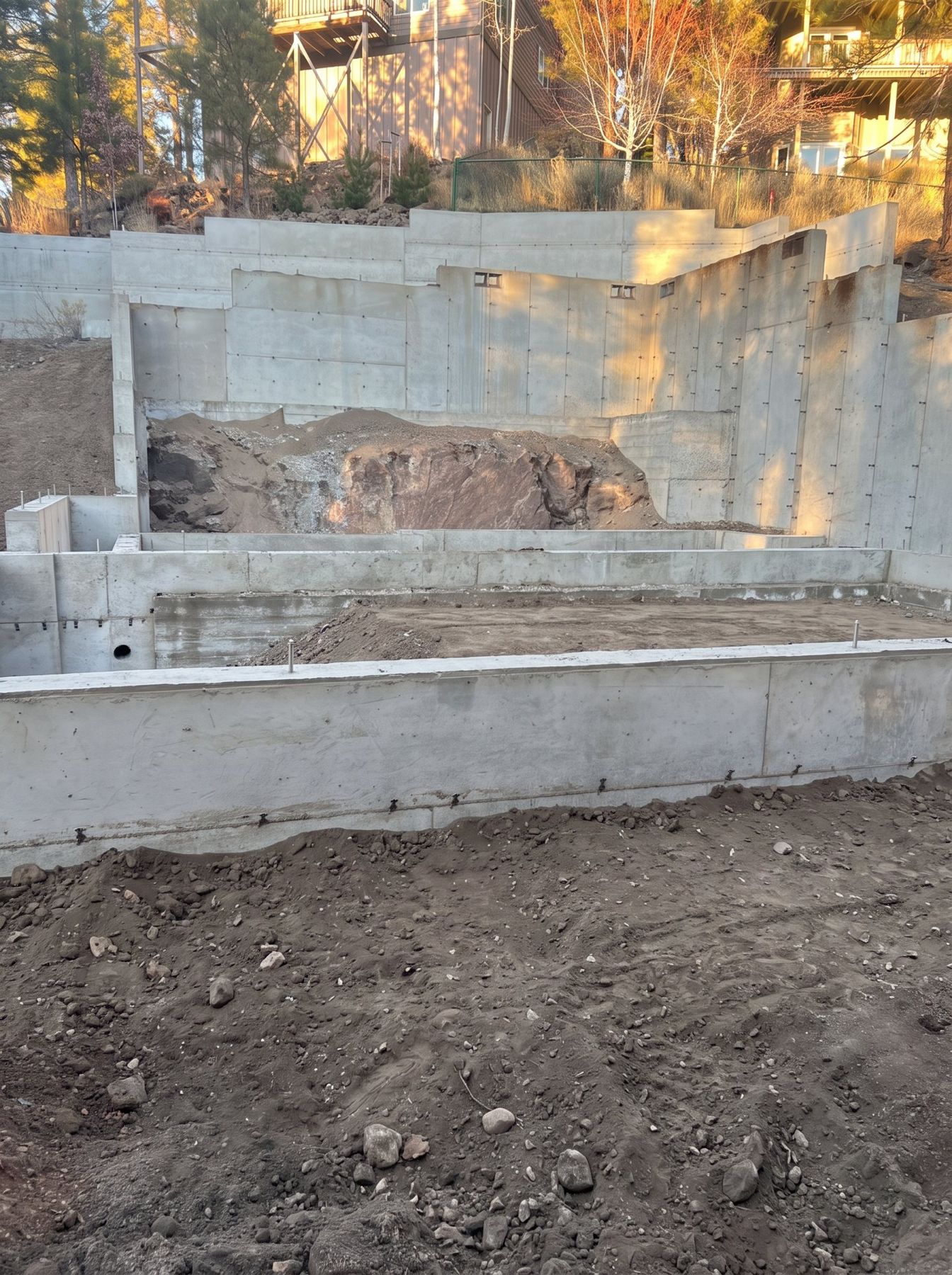 Poured concrete stem walls and footings stepping up a sloped Bend lot, ready for backfill
