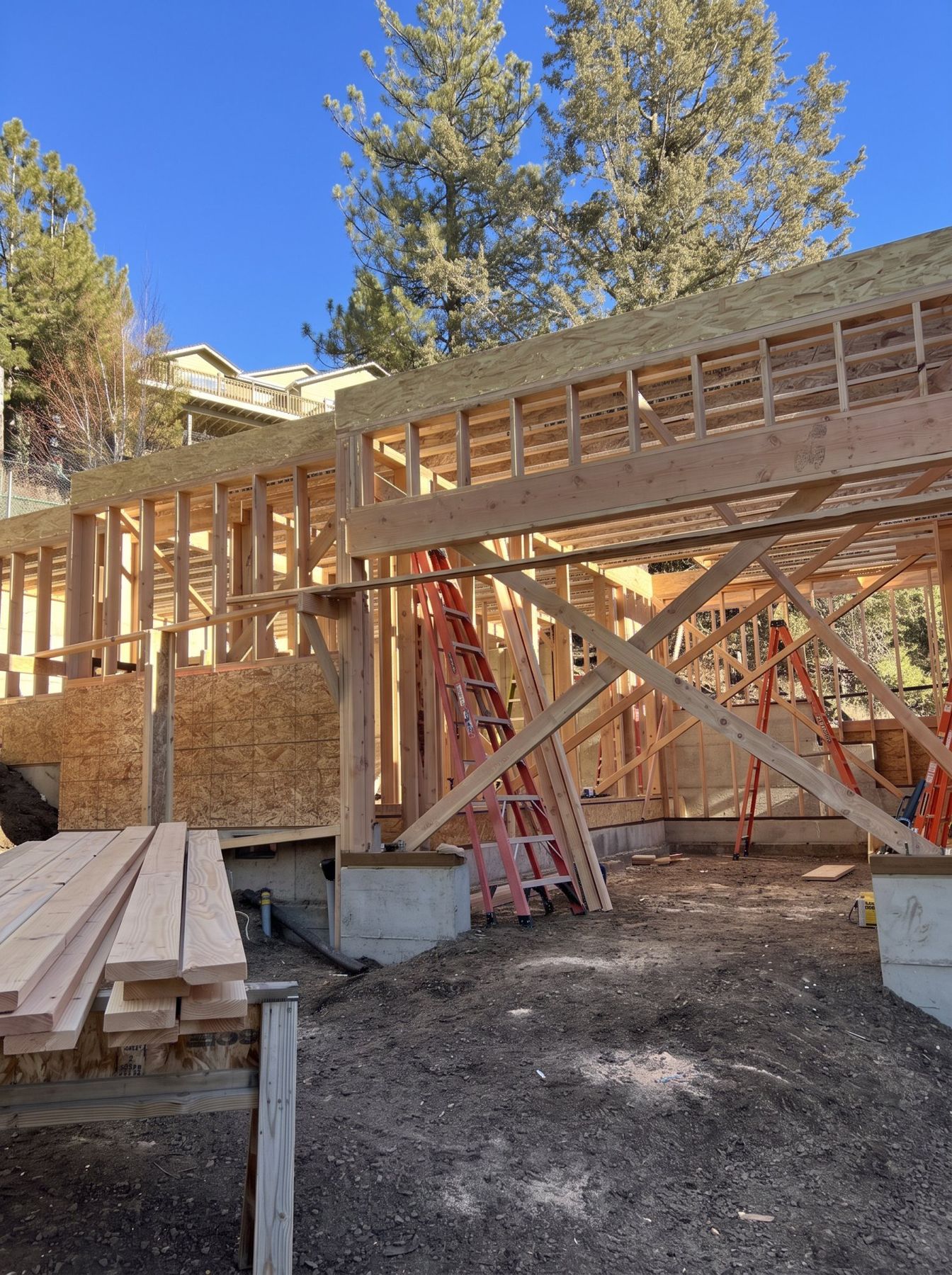 Framed walls and header beams with temporary bracing, sheathing started