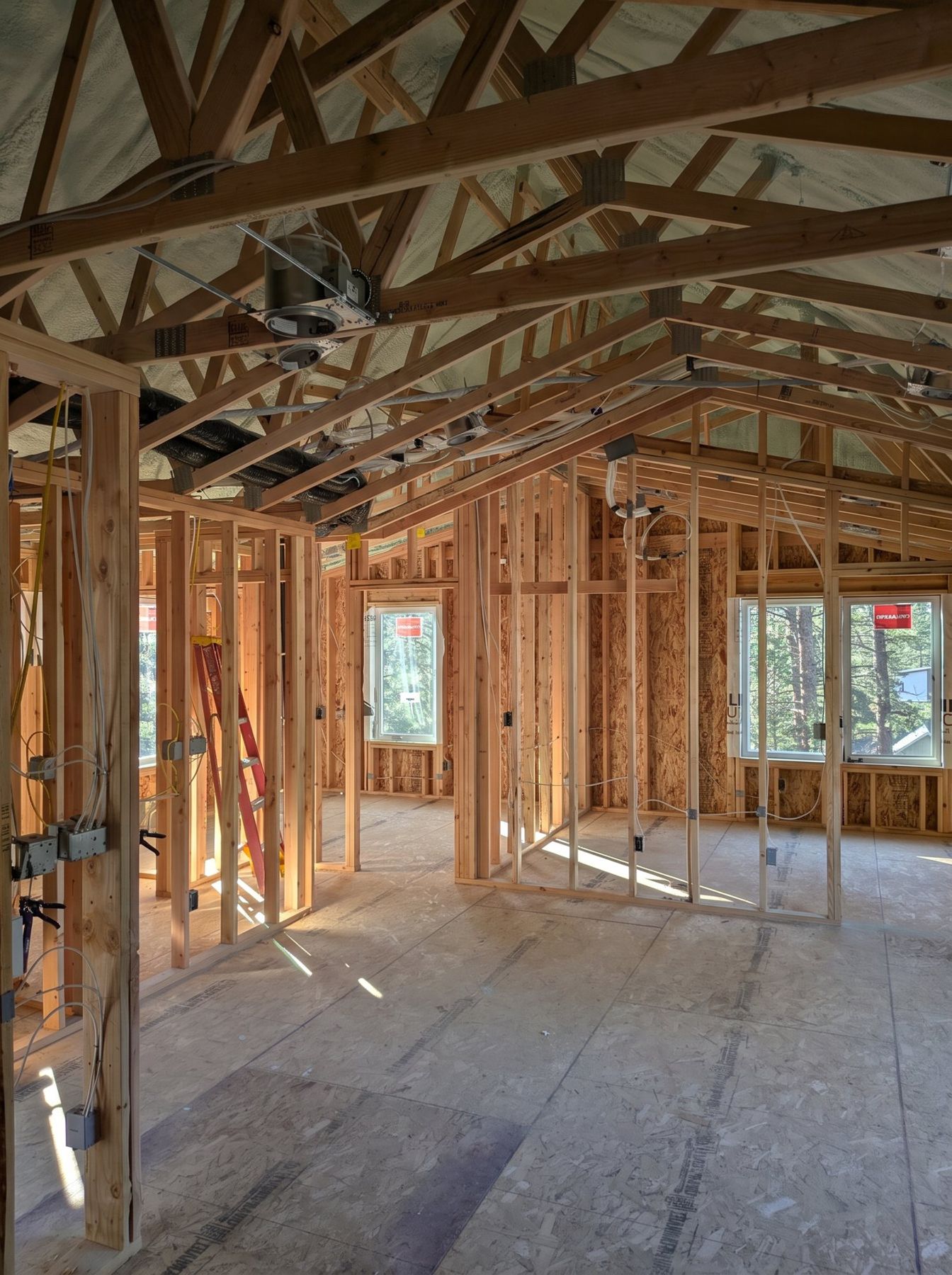 Open wall framing and roof trusses inside before the rough-ins go in